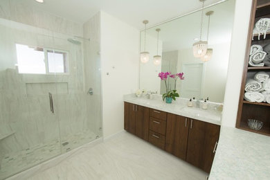 This is an example of a large contemporary ensuite bathroom in Hawaii with flat-panel cabinets, dark wood cabinets, an alcove shower, grey tiles, porcelain tiles, white walls, marble flooring, a submerged sink, marble worktops, grey floors and a hinged door.