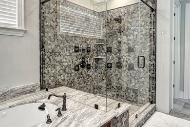 Example of a classic gray tile and pebble tile corner shower design in Charleston with an undermount tub and gray walls