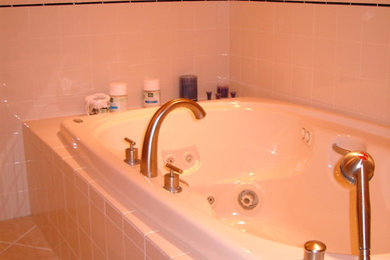 Example of a mid-sized master white tile ceramic tile drop-in bathtub design in Cleveland with orange walls