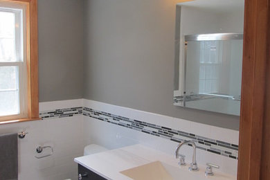 Mid-sized trendy 3/4 black tile, black and white tile, gray tile, white tile and matchstick tile slate floor bathroom photo in Atlanta with flat-panel cabinets, dark wood cabinets, a two-piece toilet, gray walls, an integrated sink and quartzite countertops