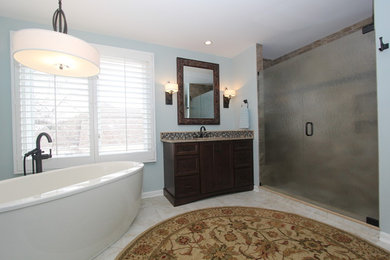 Пример оригинального дизайна: главная ванная комната среднего размера в стиле неоклассика (современная классика) с врезной раковиной, столешницей из гранита, отдельно стоящей ванной, двойным душем, унитазом-моноблоком, бежевой плиткой, каменной плиткой, зелеными стенами и полом из керамической плитки