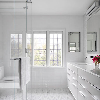Walk-in shower - contemporary white tile and subway tile walk-in shower idea in New York with flat-panel cabinets, gray cabinets, an undermount sink, marble countertops and a one-piece toilet