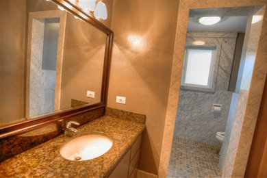 Diseño de cuarto de baño clásico pequeño con puertas de armario de madera oscura, encimera de granito, baldosas y/o azulejos beige, paredes beige, suelo con mosaicos de baldosas y aseo y ducha