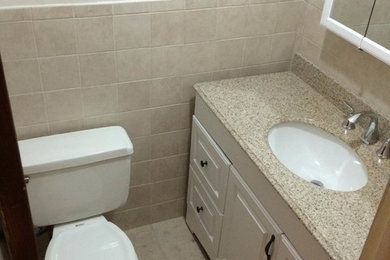 Example of a small 3/4 beige tile and ceramic tile ceramic tile bathroom design in New York with an undermount sink, granite countertops and a two-piece toilet