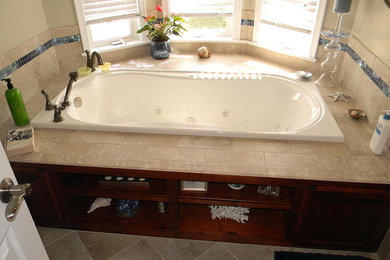 Foto de cuarto de baño clásico renovado con puertas de armario de madera en tonos medios, baldosas y/o azulejos beige, bañera encastrada y paredes beige
