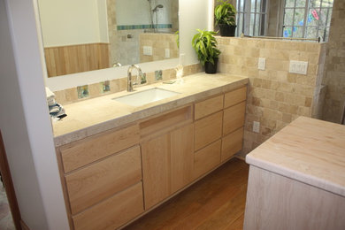 Foto de cuarto de baño contemporáneo con armarios con paneles lisos, puertas de armario de madera clara y encimera de esteatita