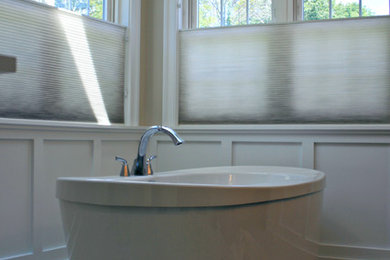 Imagen de cuarto de baño principal clásico renovado de tamaño medio con armarios con paneles empotrados, puertas de armario blancas, bañera exenta, paredes beige y suelo de travertino