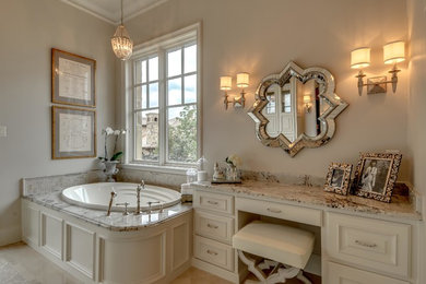 ダラスにあるトラディショナルスタイルのおしゃれな浴室 (落し込みパネル扉のキャビネット、白いキャビネット、ドロップイン型浴槽、ベージュの壁) の写真