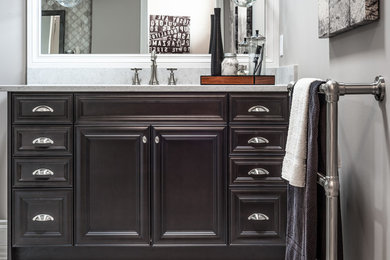 Bathroom - mid-sized traditional bathroom idea in Calgary with raised-panel cabinets, dark wood cabinets, gray walls, an undermount sink and quartzite countertops