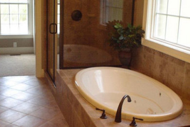 他の地域にある広いおしゃれなマスターバスルーム (ドロップイン型浴槽、コーナー設置型シャワー、ベージュのタイル、セラミックタイル、セラミックタイルの床) の写真