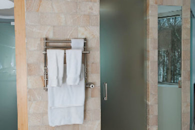 Example of a large beige tile pebble tile floor double shower design in New York with a one-piece toilet and white walls