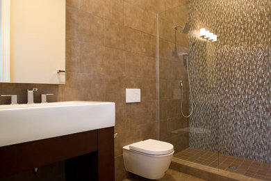 Example of a mid-sized minimalist brown tile and porcelain tile porcelain tile doorless shower design in Orlando with furniture-like cabinets, brown cabinets, a wall-mount toilet, brown walls and solid surface countertops