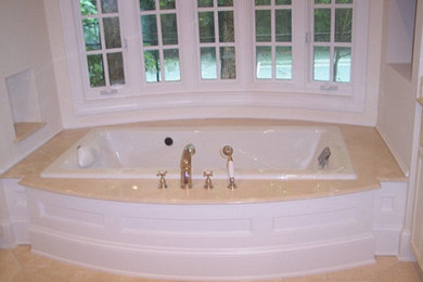 Diseño de cuarto de baño tradicional con lavabo encastrado, armarios con paneles empotrados, puertas de armario blancas, bañera encastrada y baldosas y/o azulejos blancos