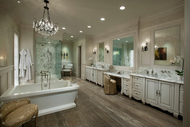 Foto di un'ampia stanza da bagno classica con lavabo sottopiano, ante con bugna sagomata, ante beige, vasca freestanding, doccia ad angolo e pareti beige