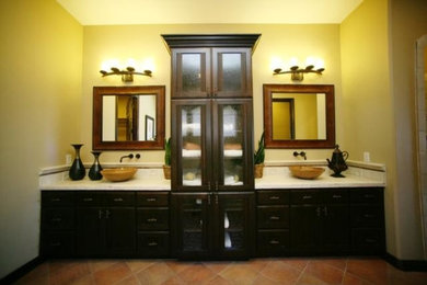 Immagine di una stanza da bagno padronale chic di medie dimensioni con ante con riquadro incassato, ante in legno bruno, pareti beige, pavimento in terracotta, lavabo a bacinella e pavimento beige