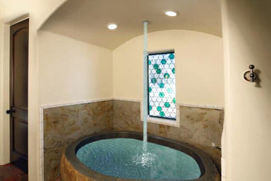 Example of a mid-sized master stone tile terra-cotta tile freestanding bathtub design in Santa Barbara with white walls