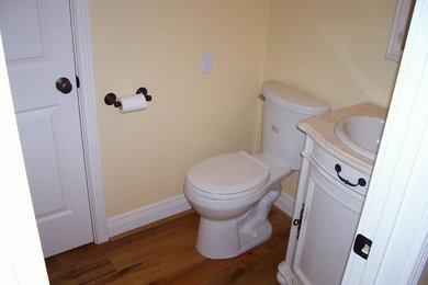 Example of a mid-sized classic 3/4 medium tone wood floor bathroom design in Louisville with beaded inset cabinets, white cabinets, marble countertops, a one-piece toilet and yellow walls