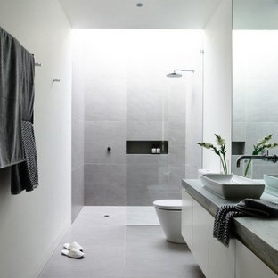 Immagine di una grande stanza da bagno padronale moderna con ante lisce, ante bianche, doccia a filo pavimento, piastrelle grigie, piastrelle di cemento, pareti bianche, pavimento in cemento, lavabo a bacinella, top in cemento, pavimento grigio e doccia aperta