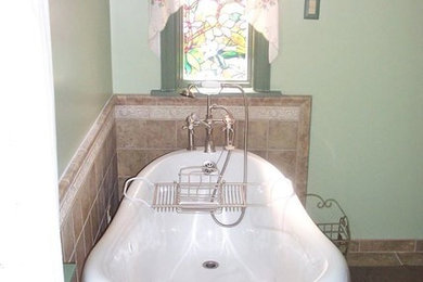 Example of a small ceramic tile claw-foot bathtub design in New York with green walls