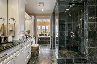 This is an example of a large traditional ensuite bathroom in Atlanta with raised-panel cabinets, white cabinets, an alcove bath, an alcove shower, a two-piece toilet, black tiles, stone tiles, beige walls, marble flooring, a submerged sink, marble worktops, multi-coloured floors and a hinged door.