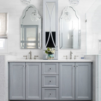 Mid-sized elegant master white tile and marble tile porcelain tile and gray floor corner shower photo in New York with a one-piece toilet, quartzite countertops, a hinged shower door, recessed-panel cabinets, gray cabinets, white walls, an undermount sink and white countertops