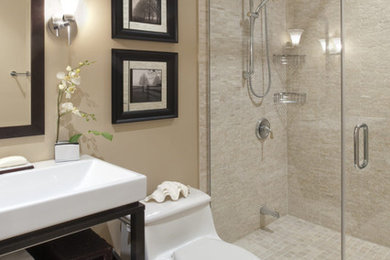 Alcove shower - mid-sized transitional 3/4 beige tile and matchstick tile beige floor alcove shower idea in Orange County with flat-panel cabinets, dark wood cabinets, a one-piece toilet, beige walls, a trough sink, solid surface countertops and a hinged shower door