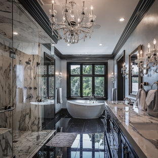 Foto di una stanza da bagno tradizionale con ante con bugna sagomata, ante nere, vasca freestanding, doccia a filo pavimento, pistrelle in bianco e nero, pareti grigie, lavabo sottopiano, pavimento nero, porta doccia a battente e top bianco