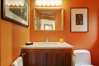 Small contemporary bathroom in Seattle with flat-panel cabinets, dark wood cabinets, a one-piece toilet, orange walls, a submerged sink and quartz worktops.