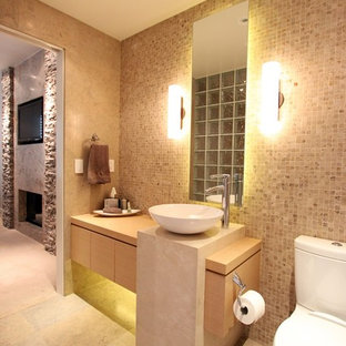 Großes Modernes Badezimmer En Suite mit flächenbündigen Schrankfronten, hellen Holzschränken, Toilette mit Aufsatzspülkasten, Terrakottafliesen, bunten Wänden, Kalkstein, Aufsatzwaschbecken und Waschtisch aus Holz in Orange County