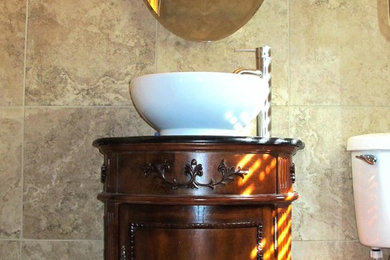 Foto de cuarto de baño principal con lavabo sobreencimera, puertas de armario de madera en tonos medios y baldosas y/o azulejos beige