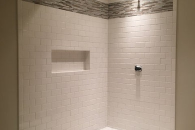 Foto de cuarto de baño tradicional renovado con ducha esquinera, baldosas y/o azulejos blancos, baldosas y/o azulejos de cemento, paredes grises y suelo de baldosas de porcelana