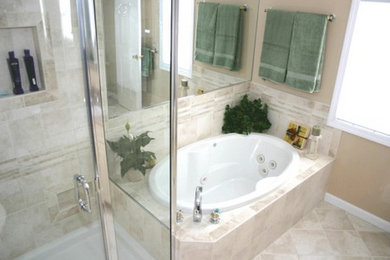 Imagen de cuarto de baño principal de tamaño medio con bañera empotrada, ducha esquinera, baldosas y/o azulejos beige, paredes beige y suelo de mármol