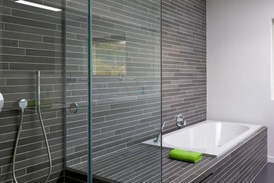 Пример оригинального дизайна: большая главная ванная комната в современном стиле с душем без бортиков, серой плиткой, удлиненной плиткой, белыми стенами, накладной ванной, бетонным полом и серым полом