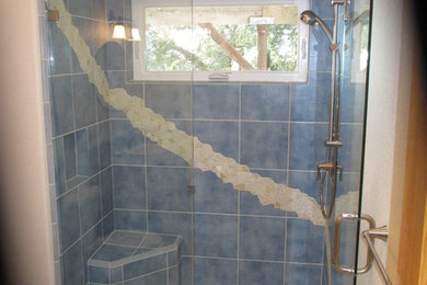 Diseño de cuarto de baño actual de tamaño medio con ducha empotrada, sanitario de una pieza, baldosas y/o azulejos azules, baldosas y/o azulejos de porcelana, paredes blancas y suelo de baldosas tipo guijarro