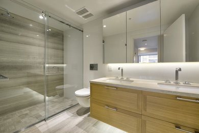 Diseño de cuarto de baño flotante contemporáneo con puertas de armario de madera oscura, ducha a ras de suelo, sanitario de pared, lavabo bajoencimera, ducha con puerta corredera y tendedero