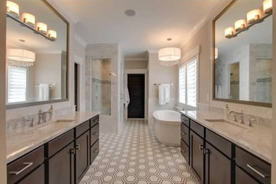 ナッシュビルにある巨大なモダンスタイルのおしゃれなマスターバスルーム (アンダーカウンター洗面器、落し込みパネル扉のキャビネット、濃色木目調キャビネット、ライムストーンの洗面台、置き型浴槽、アルコーブ型シャワー、一体型トイレ	、白いタイル、白い壁、セラミックタイルの床) の写真