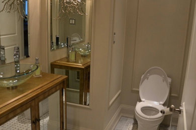 Mid-sized minimalist 3/4 marble floor bathroom photo in Ottawa with a vessel sink, glass-front cabinets, medium tone wood cabinets, a two-piece toilet and beige walls