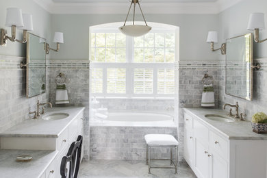 Example of a classic gray tile and subway tile bathroom design in DC Metro with an undermount sink, white cabinets and an undermount tub