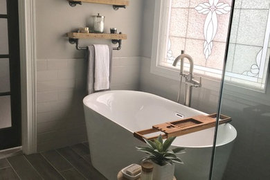 Bathroom - mid-sized transitional master subway tile and white tile laminate floor and gray floor bathroom idea in Other with a one-piece toilet, gray walls, shaker cabinets, gray cabinets, a hinged shower door and a vessel sink