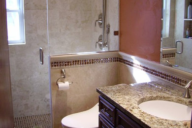 Corner shower - master beige tile ceramic tile corner shower idea in Denver with a drop-in sink, a one-piece toilet and orange walls