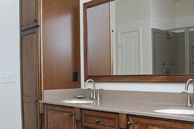Ejemplo de cuarto de baño de tamaño medio con lavabo encastrado, armarios con paneles con relieve, puertas de armario de madera en tonos medios, baldosas y/o azulejos blancos y paredes blancas