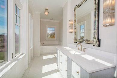 Transitional bathroom photo in New York with flat-panel cabinets, orange cabinets, an undermount tub, an undermount sink and marble countertops
