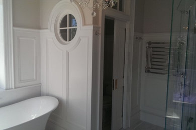 This is an example of a medium sized victorian ensuite bathroom in Boston with shaker cabinets, white cabinets, a claw-foot bath, a corner shower, beige walls, cement flooring, a submerged sink, brown floors and a hinged door.
