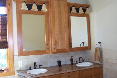 Ejemplo de cuarto de baño grande con lavabo encastrado, puertas de armario de madera oscura, encimera de granito, baldosas y/o azulejos beige y paredes beige