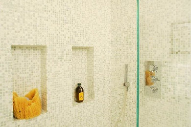 Inspiration for a mid-sized transitional master gray tile, white tile and mosaic tile corner shower remodel in New York with a two-piece toilet, white walls, a wall-mount sink and a hinged shower door