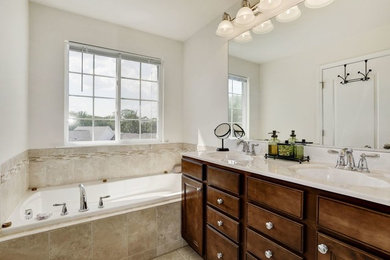 Mid-sized elegant master porcelain tile and beige floor drop-in bathtub photo in Raleigh with recessed-panel cabinets, dark wood cabinets, gray walls, an undermount sink and beige countertops