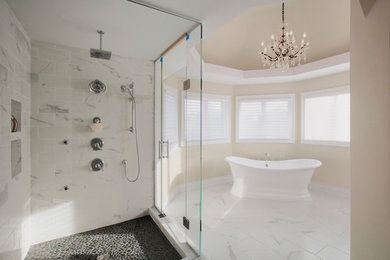 他の地域にある広いトランジショナルスタイルのおしゃれなマスターバスルーム (置き型浴槽、コーナー設置型シャワー、グレーのタイル、白いタイル、石タイル、ベージュの壁、大理石の床、白い床、開き戸のシャワー) の写真