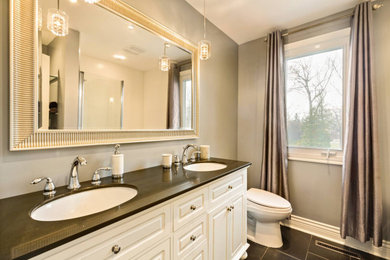 Bathroom - mid-sized traditional master white tile and ceramic tile ceramic tile and black floor bathroom idea in Montreal with shaker cabinets, white cabinets, granite countertops, a one-piece toilet, gray walls, an undermount sink and a hinged shower door
