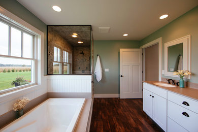 インディアナポリスにあるトラディショナルスタイルのおしゃれなマスターバスルーム (シェーカースタイル扉のキャビネット、大型浴槽、コーナー設置型シャワー、緑の壁、無垢フローリング、アンダーカウンター洗面器、珪岩の洗面台) の写真