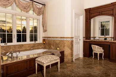 Пример оригинального дизайна: большая главная ванная комната в классическом стиле с фасадами с выступающей филенкой, темными деревянными фасадами, полновстраиваемой ванной, коричневой плиткой, каменной плиткой, белыми стенами, мраморным полом, врезной раковиной и мраморной столешницей